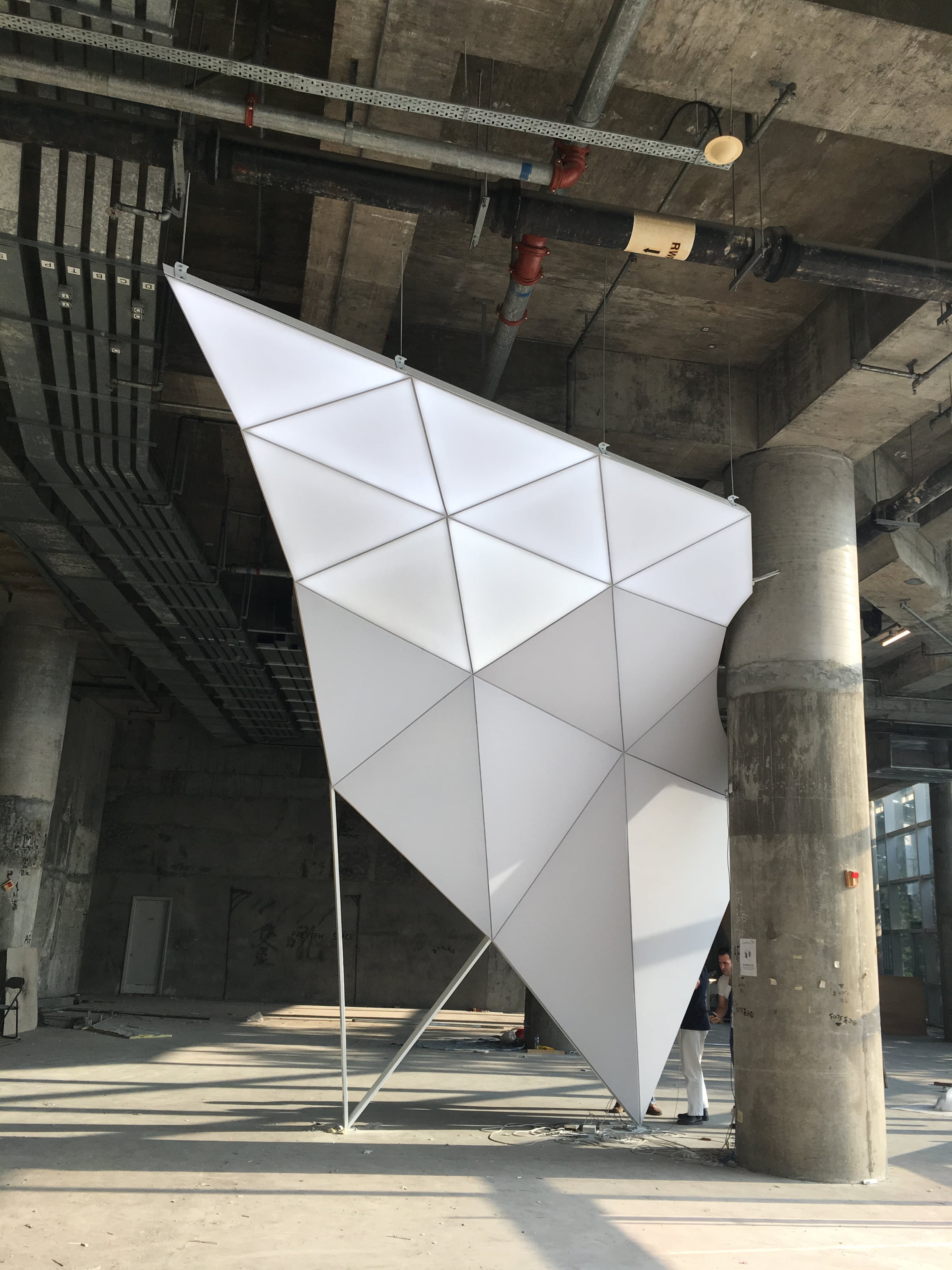 Maqueta iluminada a escala real de la matriz triangular de aluminio durante la obra